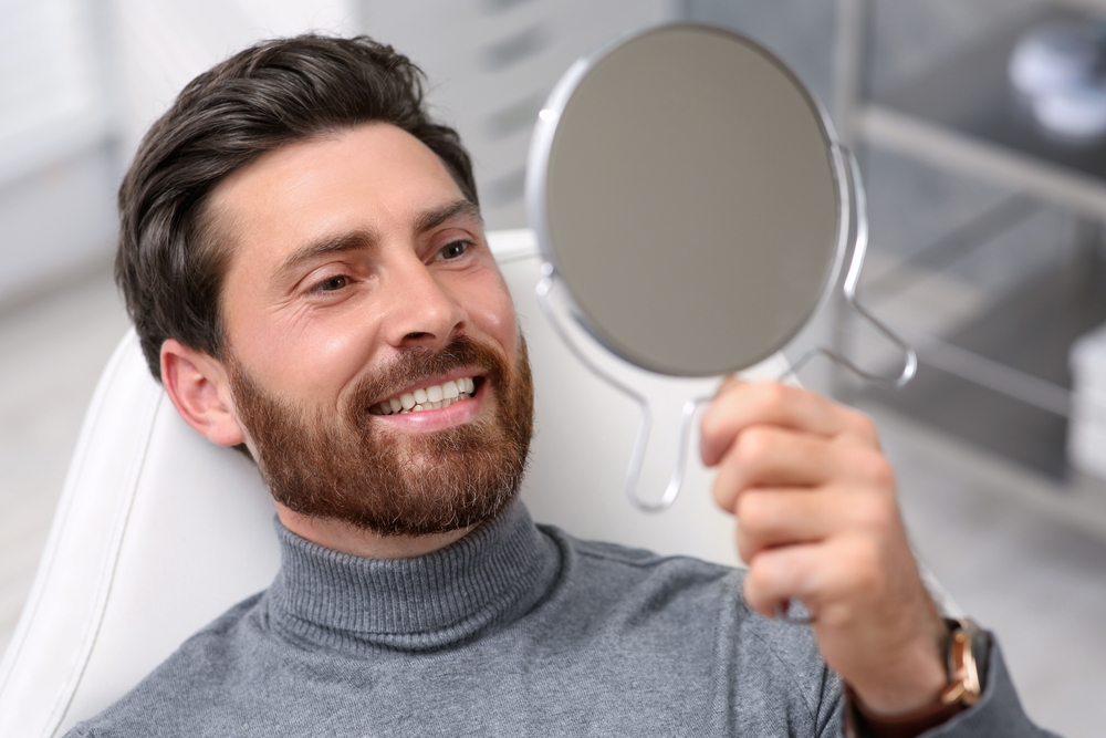 Patient smiling while reviewing his dental treatment result
